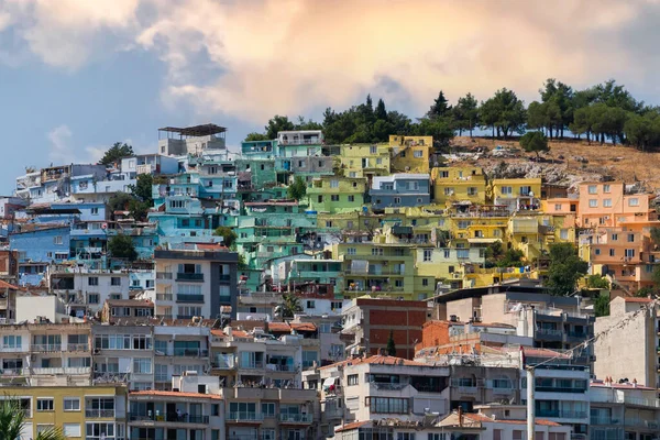 Colorful Kusadasi houses on the hill seen through palm leaves, , Aydin, Turkey