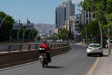 Ankara, Türkiye-23 Mayıs 2021: Pandemik sırasında en yoğun trafikte motosiklet kullanan ve şehir merkezine yaklaşan motosikletlinin arka plandaki görüntüsü biraz bulanık.