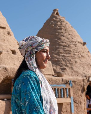 Sanli Urfa, Türkiye - 12 Eylül 2020: Harran evlerinin önünde yerel kıyafetlerle poz veren turistler.