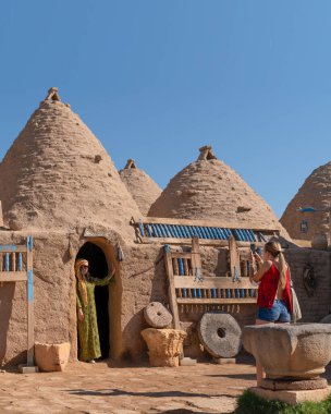 Sanli Urfa, Türkiye - 12 Eylül 2020: Harran evlerinin önünde yerel kıyafetlerle poz veren turistler.