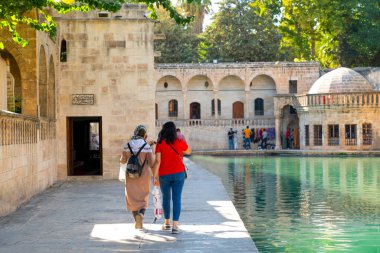 Balikli Gol yakınlarındaki iki kadın turist ve arka plandaki tarihi binalar, Sanliurfa, Türkiye