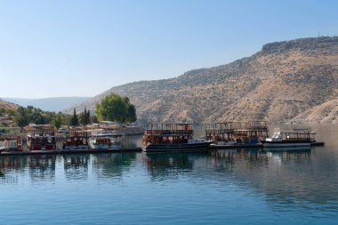 Halfeti, Sanliurfa / Türkiye - 15 Eylül 2020: Arkaplanda turistik tekne ve tepe bulunan Baraj Gölü.