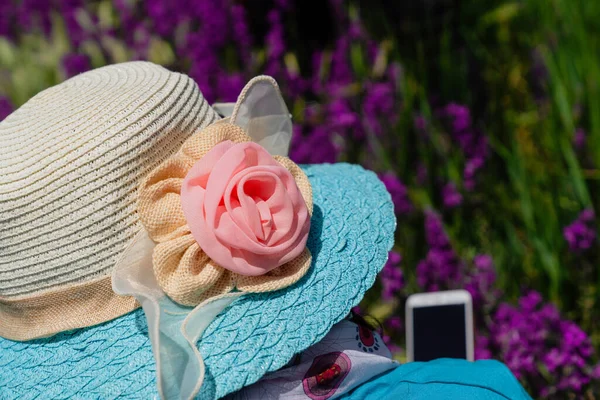戴着花纹草帽的女人的后视镜是戴着花的手机 — 图库照片