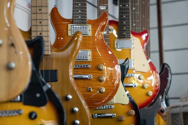 Foco Seletivo Diferentes Guitarras Elétricas Uma Fileira Pendurada Uma Loja — Fotografia de Stock