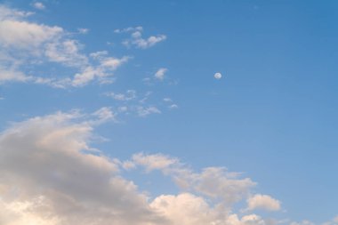 Benzer ruh, mavi gökyüzünde kabarık beyaz bulutlar Arka plan ve küçük dolunay.