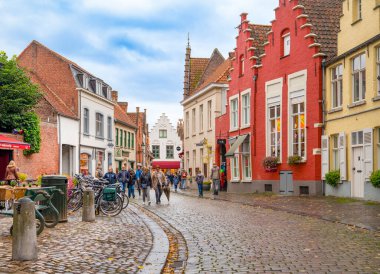 Bruges, Belçika - 11 Ekim 2019: Yağmurlu bir günün ardından Bruges caddesinde yürüyen turistler