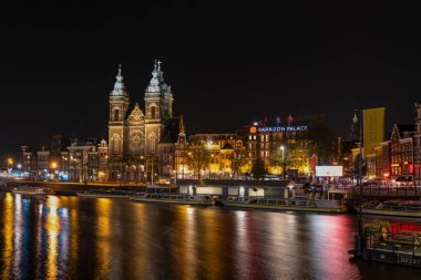 Amsterdam / Hollanda - Ekim 06: Amsterdam Kanalı Gece Şehir Manzarası, Saint Nicholas Bazilikası ve Barbizon Sarayı, Hollanda. Uzun pozlama.