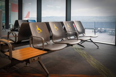 Empty disabled seats at an airport in the waiting area before boarding. clipart