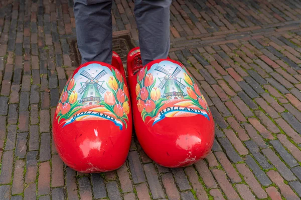 Big clogs with man\'s leg in Holland. Man try big clogs in Nederland.