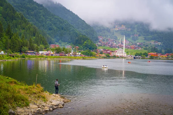Trabzon / Türkiye - 07 Ağustos 2019: Uzungöl 'ün panoramik görünümü Türkiye' de turistik bir ilgi odağı. Uzungol 'da balıkçılık ve kürek tekneleri. Uzungol 'da balık tutmak.