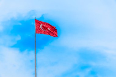 Mavi gökyüzünde dalgalanan dev bir Türk bayrağı.