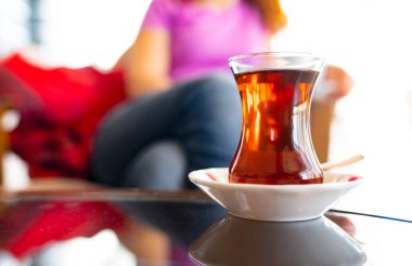 Türk kadını ince belli bardak 'tan geleneksel Türk çayı içiyor