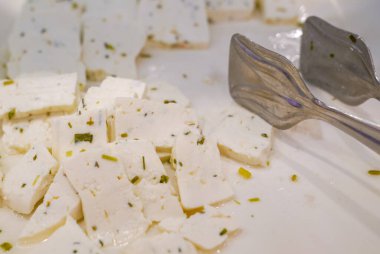 Metal maşayla dilimlenmiş Herby peyniri.