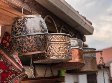 El yapımı antika eşyalar, sokakta çarşının önünde asılı sahte bakır kovalar..