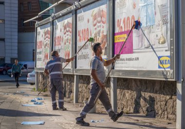 Ankara / Türkiye-23 Haziran 2019: İşçiler bir reklam panosuna reklam koyup kaldırdılar.