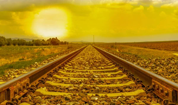 Järnvägen Solnedgången Grönt Fält Och Molnig Himmel — Stockfoto