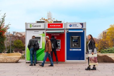 Ankara / Türkiye-Aralık 01-2018: İnsanlar bir parkın yakınındaki sokakta çeşitli bankaların ATM 'lerini (Otomatik Teller Machine) kullanıyorlar