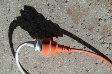 Elektrik ekipmanlarını birbirine bağlamak için iki yuvarlak raptiyeyle uzatma kablosu ve fişi.