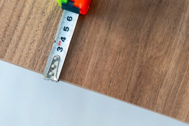 Yeşil ve turuncu renkli ruleti olan ahşap bir masa ölçüyorum.