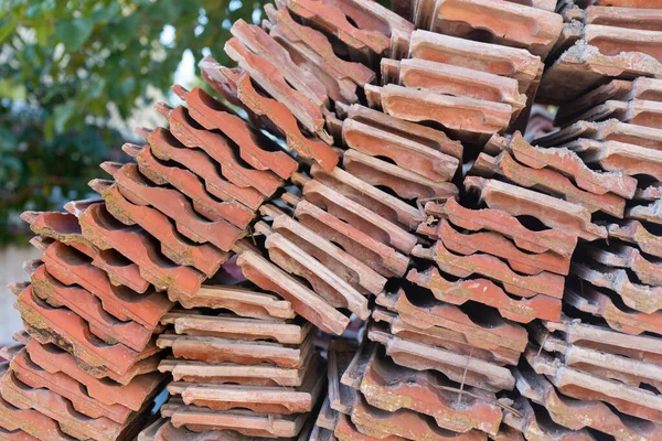 Red clay roof tile put in the stack after old tenement renovation in central Turkey, texture