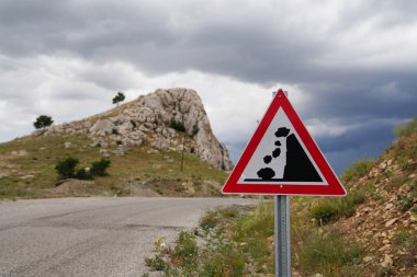 Arka planda kayalık yol işareti ve kayalık tepe kayaları, seçici odaklanma