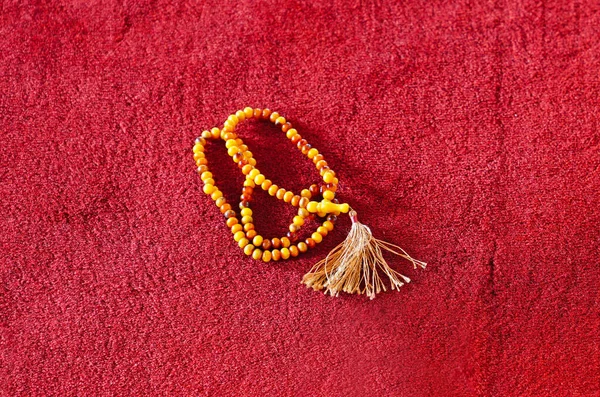 Muslim prayer beads on red carpet in a mosque