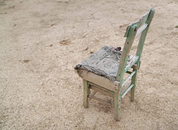 Aged wooden chair with chair pad on ground