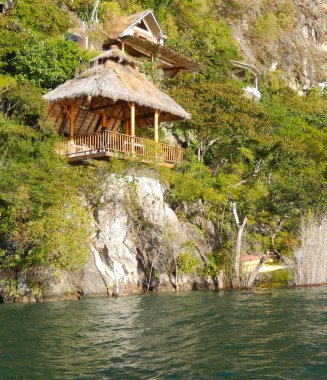 Ormanda, Atitlan Gölü 'nün yanındaki tepede kulübeler.