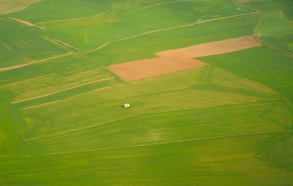 Aerial view of a lonely house among fields, agricultural parcels