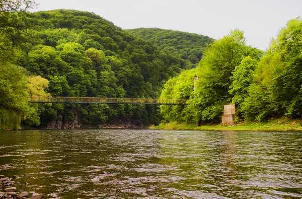 La belle rivière avec vieux pont suspendu . — Photo