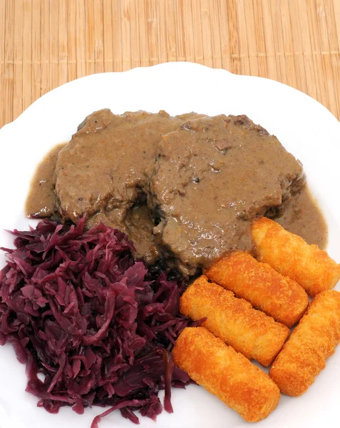 Roast of wild boar with red cabbage and potato croquettes
