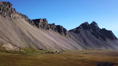 Terk edilmiş bir Viking köyü. Çimen çatıları, çim çatıları. İzlanda 'da yüksek bir dağın eteğinde yer alan bir köy. Stoksnes 'deki Vestrahorn Dağı.