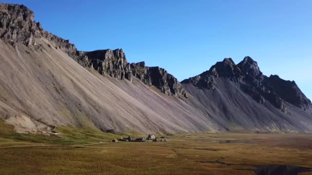 Een verlaten Vikingdorp. Dakpannen, grasdaken. Dorp gelegen op de bodem van een hoge berg in IJsland. Vestrahorn berg in Stokksnes. — Stockvideo