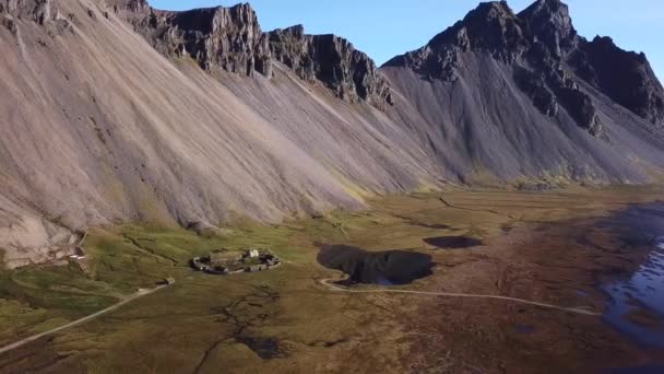En övergiven vikingaby. Torvtak, torvtak. Byn ligger på botten av ett högt berg på Island. Vestrahorn berg i Stokksnes. — Stockvideo