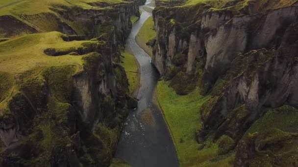 Een kloof en een canyon Fjadrargljufur in IJsland. Panoramische drone beelden. Het concept van briefkaarten en reizen. Groen gras en schilderachtige kliffen. — Stockvideo