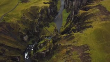 İzlanda 'da bir vadi ve bir Fjadrargljufur kanyonu. Panoramik dron görüntüleri. Kartpostal ve seyahat kavramı. Yeşil çimenler ve resimli uçurumlar.