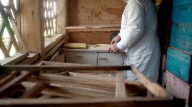 Arı kovanı için balmumu çerçeve hazırlıyorum. Arıcılık ve bal teması. Arı yetiştiricilerinin ellerine yakın çekim. Arılar için balmumu çerçeveler oluşturup onarıyoruz. elektrik kaynaklama.
