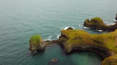 Arnarstapi 'nin Atlantik kıyısındaki Gatklettur bazalt kayasının üzerindeki manzara. İnsansız hava aracı görüntüleri. Güzel kuzey doğası. 