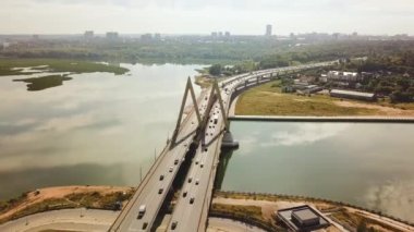 Tataristan 'ın Kazan şehrinin merkezindeki Milenyum Köprüsü manzarası. Yazın şehrin panoramasının pitoresk bir manzarası. Kazanka Nehri. İnsansız hava aracının video görüntüleri. Güneşli hava. 