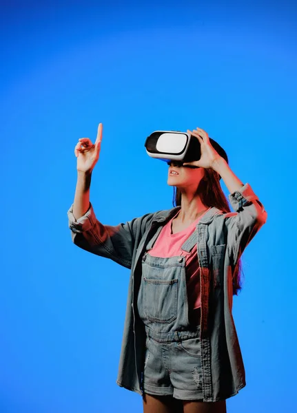 Lunettes de réalité virtuelle VR sur une fille. Il regarde vers l'avenir. Toucher le nouveau. Fantastique monde virtuel. L'émotion de l'immersion, la surprise, l'indignation, la peur, la peur, le rire, le plaisir. Concept de TVN. Photos De Stock Libres De Droits