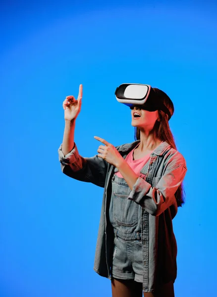 Lunettes de réalité virtuelle VR sur une fille. Il regarde vers l'avenir. Toucher le nouveau. Fantastique monde virtuel. L'émotion de l'immersion, la surprise, l'indignation, la peur, la peur, le rire, le plaisir. Concept de TVN. Images De Stock Libres De Droits