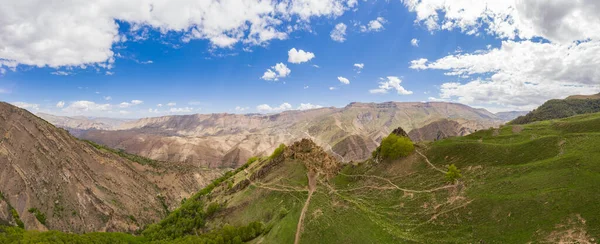 Une ancienne ville abandonnée est le village de Gamsutl au sommet d'une montagne au Daghestan. Une attraction populaire. vue du dessus depuis le drone. Panorama vertical. Image En Vente