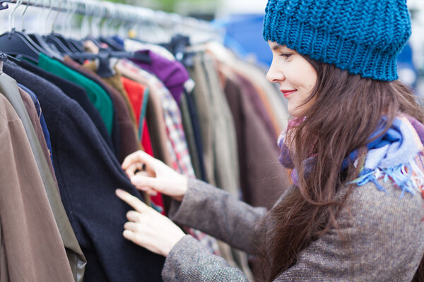 Woman choosing clothes at flea market.