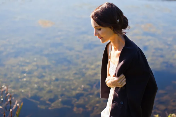 Young woman walking by water — Stock Photo, Image