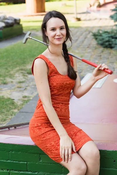 Ung kvinna med en miniatyr golf club Stockbild