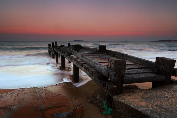 Houten pier op het strand — Stockfoto