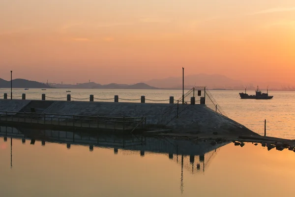 沿岸防波堤と夕方木製ボート — ストック写真