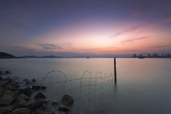 Estacas de alambre de púas y paisaje urbano con vista al mar — Foto de Stock