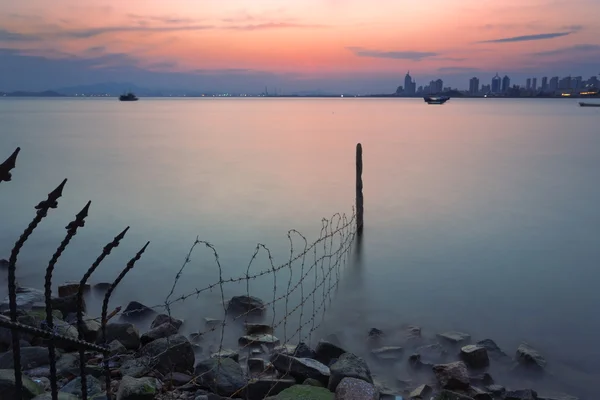 有刺鉄線のステークスと都市の海の風景を表示します。 — ストック写真