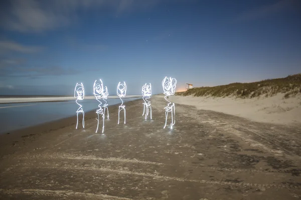 Criaturas de luz bailando en la playa — Foto de Stock